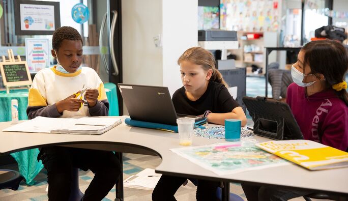 Students using both digital devices and paper